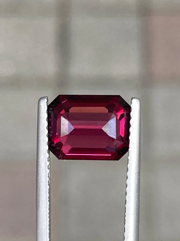 Purplish red natural rhodolite garnet under low light